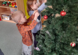 Dzieci ozdabiają świąteczne drzewko